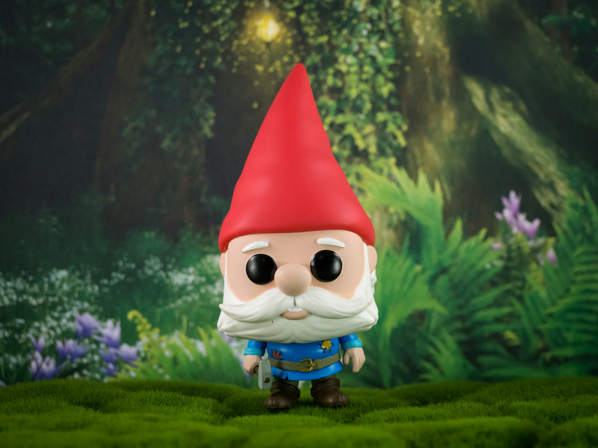 Figurine de collection en vinyle représentant un nain, posée devant un décor peint de forêt