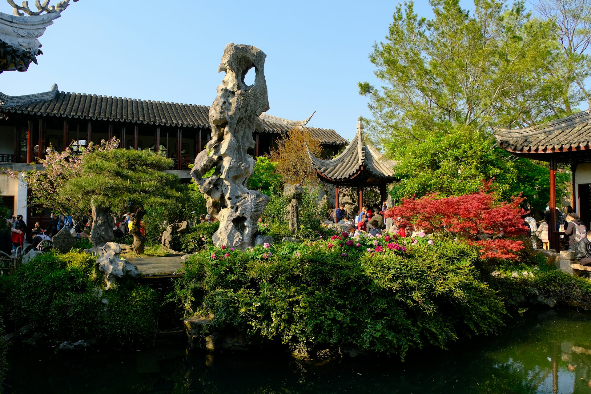 Rocher percé dressé devant les pavillons et les massifs fleuris du Jardin Liu, à Suzhou